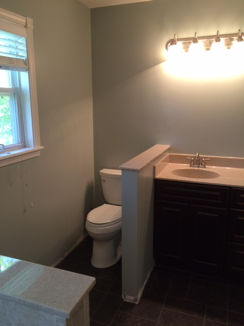 Bathroom With Vanity Sink Toilet And Window Providing Natural Light
